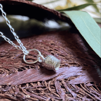 925 sterling silver Honky Nut pendant on a brown leaf